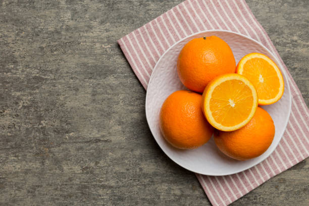 istock Flat lay of Fresh orange fruit with sliced in plate on Colored background. Top view with copy space 2093418098