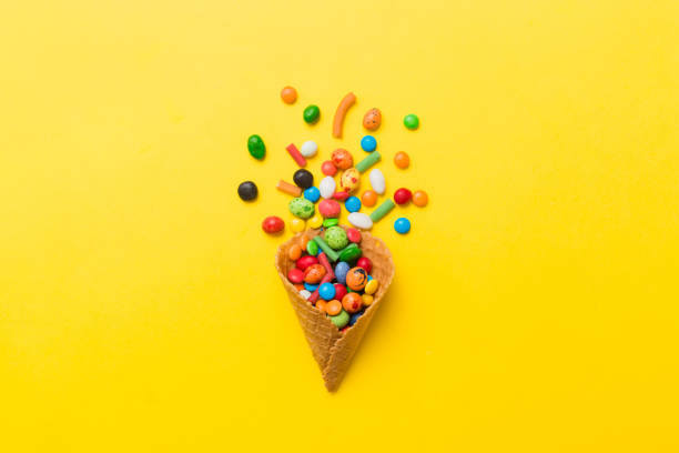 istock waffle cone full of assorted traditional candies falling out on colored background with copy space. Happy Holidays sale concept 2093419229