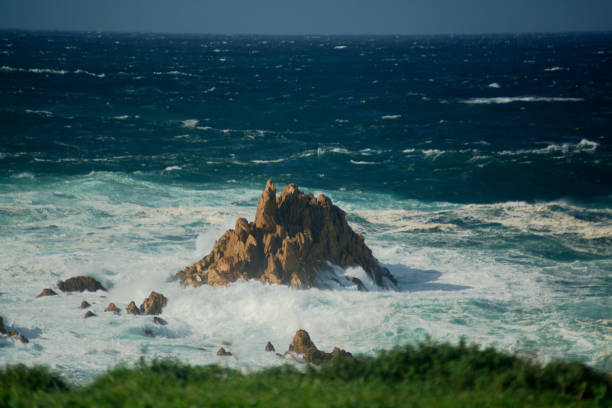 A sharp rock among a stormy sea