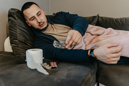 At home, a man takes his medicine with a commitment to recovery, each capsule swallowed a step closer to regaining his health and vitality, embodying his resolve to overcome illness