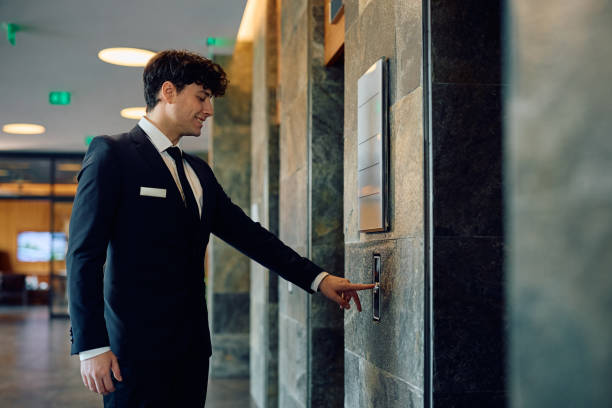 istock Happy hotel manager by the elevator in a lobby. 2093524701