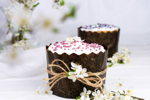 istock Festive composition with Easter cakes decorated with white icing and a sprig of cherry blossoms. Christian holiday. Close-up. Selective focus. 2093525287