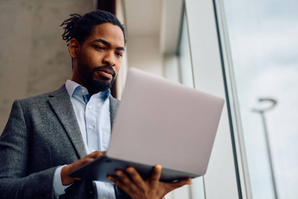 istock Black businessman using laptop by the window at his office. 2093526840
