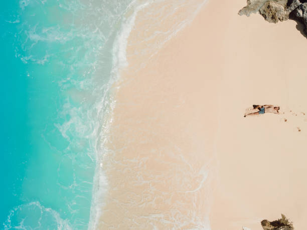 istock Handsome man sunbathing at tropical ocean beach. Aerial view 2093546962