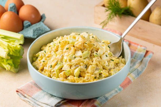 istock Potato salad made from boiled potatoes, boiled eggs, onions, celery, mustard, pickle, mayonnaise and paprika dressing. Ingredients on background. 2093560013