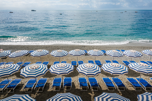 Empty Beach with two lounge chairs and beach umbrella. Azure blue water and amazing sky, Lefkada, Greece.