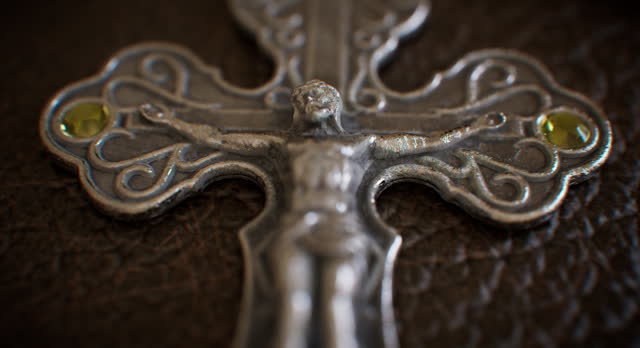 A metallic cross fixed to a leather-bound religious volume
