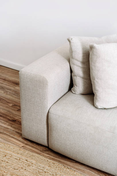 Modern sofa with comfort armrest and decorative pillows in cozy living room High angle view on sofa with comfort armrest and decorative pillows in cozy living room. Modern couch with grey upholstery and cushions. Restoration furniture concept. Dry cleaning service couch arm rest stock pictures, royalty-free photos & images