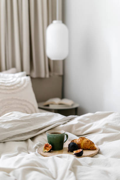 istock Selective focus on plate with cup of coffee, croissant and fruit on hotel bed 2093611594