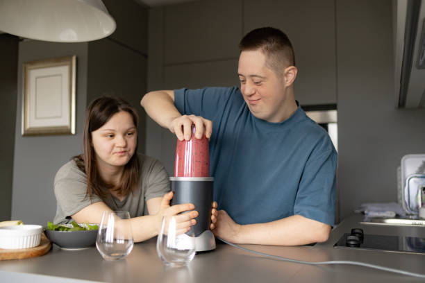 istock Couple with Down syndrome preparing healthy smoothie in the kitchen. 2093632730