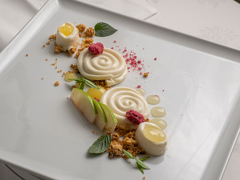 The different aromas of almonds. Spiced panna cotta, crunchy gluten-free crumble, crunchy craquelin mass, green apple coulis and water chocolate ganache