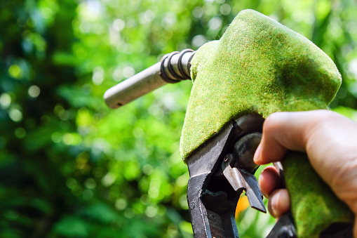 Hand holding green fuel nozzle,energy concept