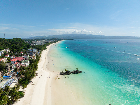 Ocean waves on white sandy beach. Coastal area with coconut trees. Boracay Island. Philippines.