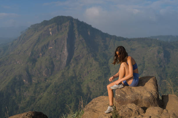 istock Young woman ties running shoe on mountain 2093701344
