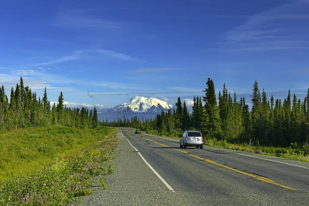 View of the Richardson Highway and volcano Mount Drum in Alaska, with frost heaves and hilly highway roads. Alaska, USA