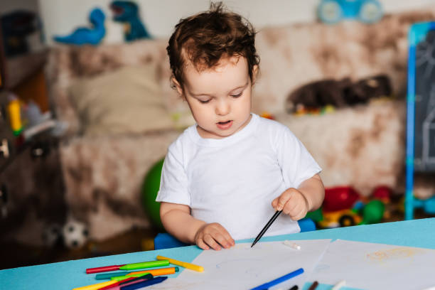 istock A cute little boy draws in his sketchbook with colored pencils 2093731098