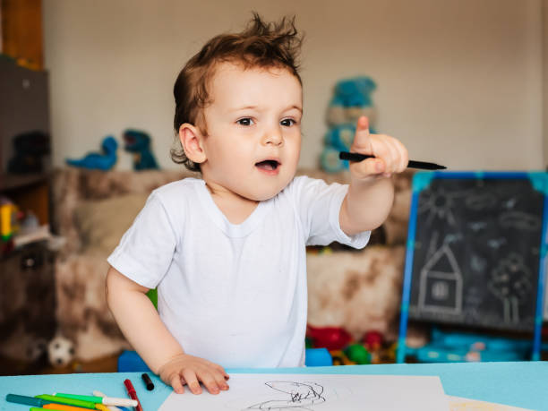 istock a small boy sits on a chair and draws with colored pencils 2093731645