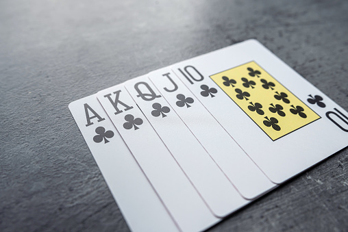 Playing cards held with hand on white background for copy space.