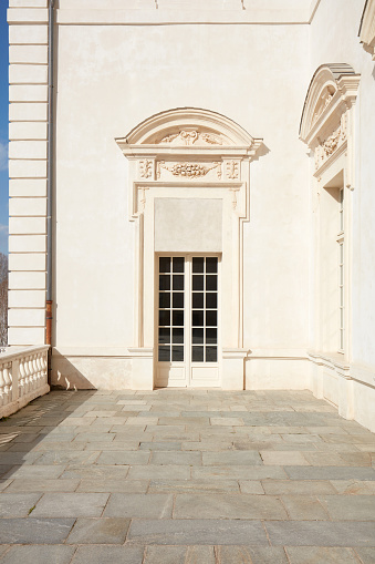 Venaria Reale, Italy - March 29 , 2023: Reggia di Venaria architecture with white portal and terrace in spring sunlight