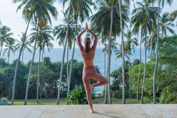 istock Young woman performs yoga outdoors 2093758078