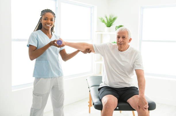 istock Black physiotherapist helping senior man with in clinic. Elderly man undergoing physiotherapy treatment for injury 2093760229