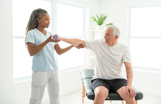 istock Black physiotherapist helping senior man with in clinic. Elderly man undergoing physiotherapy treatment for injury 2093760350