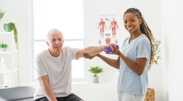 istock Black physiotherapist helping senior man with in clinic. Elderly man undergoing physiotherapy treatment for injury 2093760677