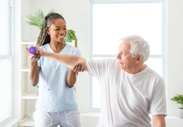 istock Black physiotherapist helping senior man with in clinic. Elderly man undergoing physiotherapy treatment for injury 2093760751