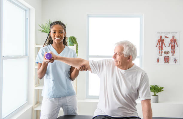 istock Black physiotherapist helping senior man with in clinic. Elderly man undergoing physiotherapy treatment for injury 2093760752