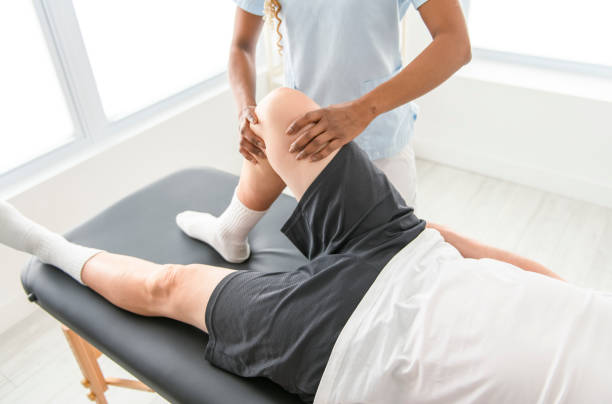 istock Black physiotherapist helping senior man with in clinic. Elderly man undergoing physiotherapy treatment for injury 2093761807