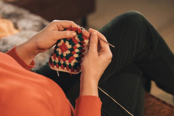 istock A woman is sitting on a couch and knitting 2093762358