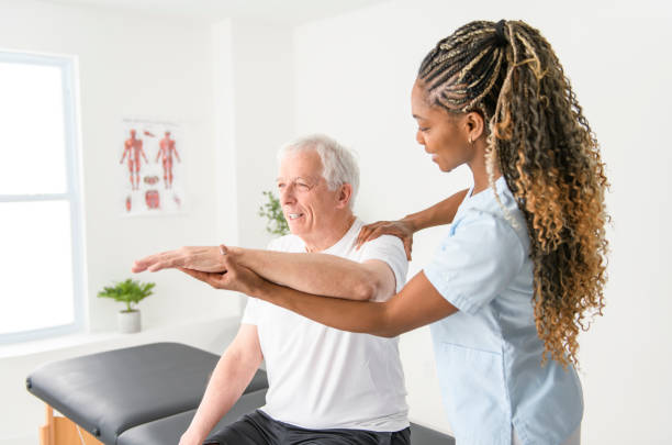 istock Black physiotherapist helping senior man with in clinic. Elderly man undergoing physiotherapy treatment for injury 2093763465