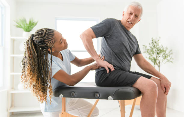 istock Black physiotherapist helping senior man with in clinic. Elderly man undergoing physiotherapy treatment for injury 2093763675