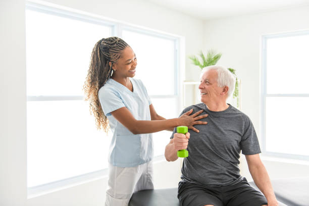 istock Black physiotherapist helping senior man with in clinic. Elderly man undergoing physiotherapy treatment for injury 2093763986