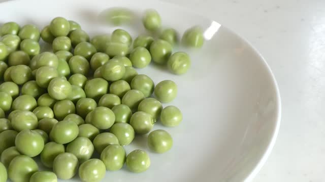 Pour the green peas into the dish intermittently without spilling.