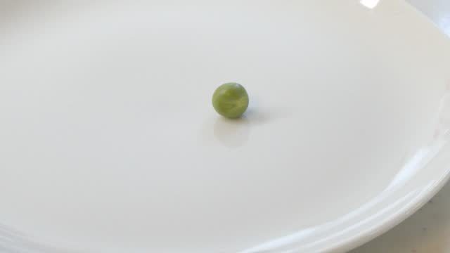 Remove a small amount of green peas from the plate with chopsticks until all are gone.