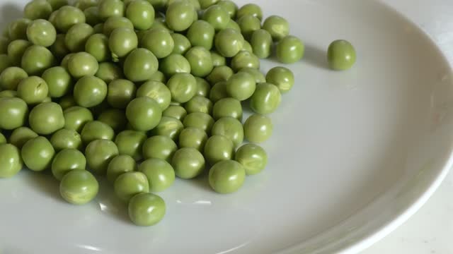 Pour the green peas all at once into the plate.