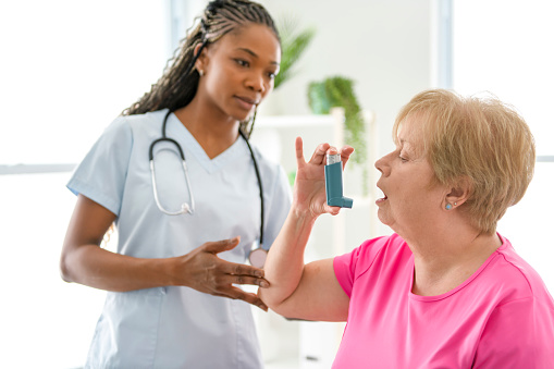 A Doctor is telling to her patient how to use inhaler.