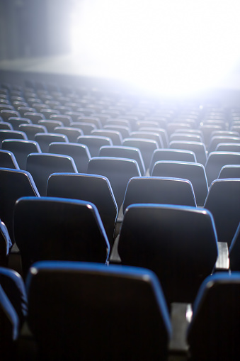 empty theater seats with bright wight light coming from stage