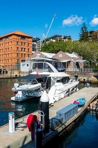Sydney, Australia - Aug 28, 2022: Pleasure cruise boat berthed along Jones Bay Wharf jetty at Pyrmont. People carrying out preparatory maintenance work on the boat.
