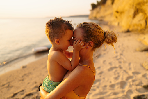 Photo of a young boy sharing some special moments with his mom, while spending some quality time together on the local beach