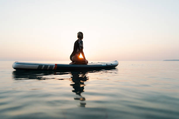 istock Young woman relaxing on a paddleboard 2093803831