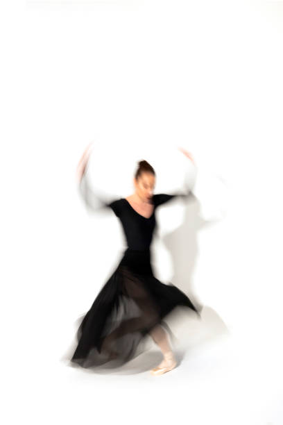 istock Young ballerina in black skirt dances in studio light.Long exposure. White Background 2093809718