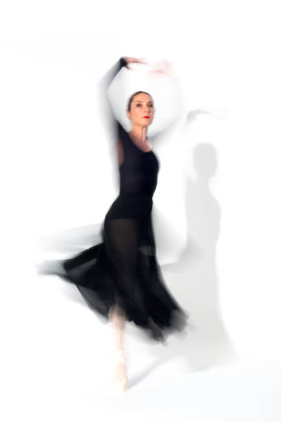 istock Young ballerina in black skirt dances in studio light.Long exposure. White Background 2093809723