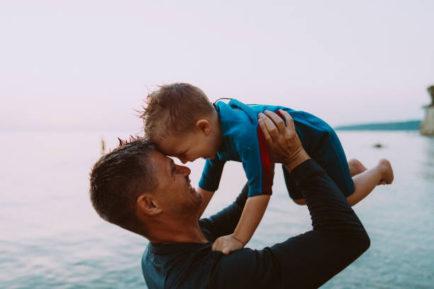 Photo of smiling boy and his dad at the beach.