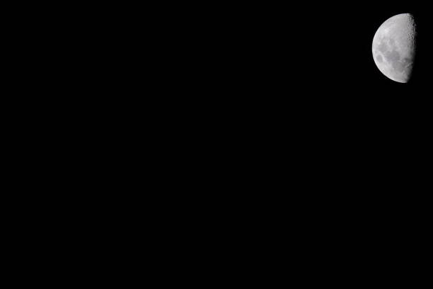 istock High resolution half moon photo on a uniform black background, which is ideal for use as a presentation slide template.  The moon is located in the top right corner, which will be next to the title of the slide. 2093816181