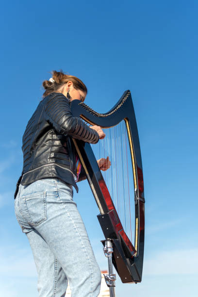istock Harpist with electronic harp studying on the roof 2093818282