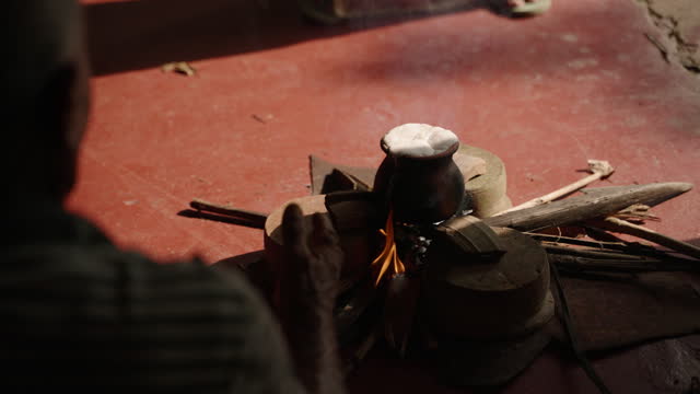 Clay pot with milk boils over open flames, symbolizing prosperity in Sri Lanka Vesak festival. Traditional ritual performed outdoors, smoky backdrop, signifies abundance on Buddha birthday.