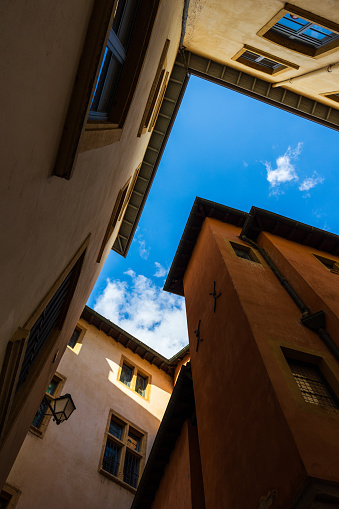 View towards the sky, surrounded by typical ancient buildings, from an alley in Old Lyon