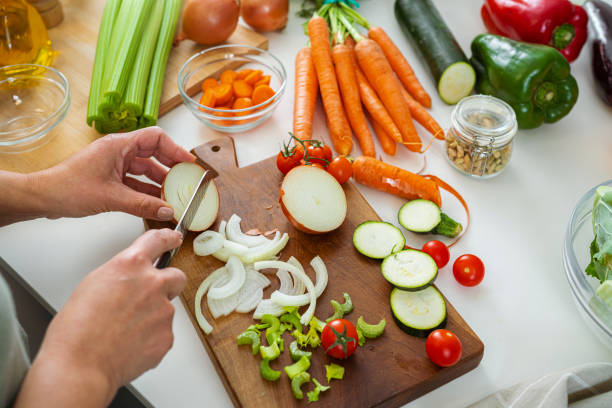 istock Woman slicing fresh organic vegetables on kitchen counter 2093870735
